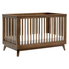 a wooden crib with white sheets on the bottom and side rails, against a white background