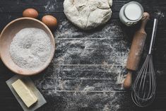 flour, eggs, butter and other ingredients on a wooden table with utensils