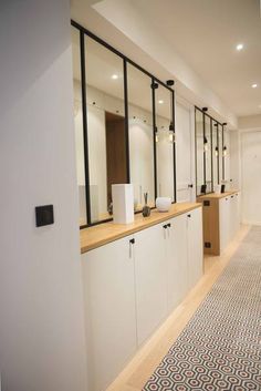 an image of a long hallway with mirrors and sinks on the wall in front of them