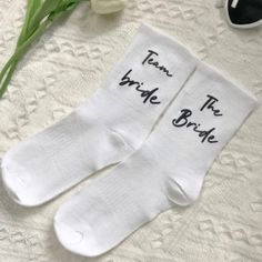 two white socks with the words team bride and groom written on them next to sunglasses