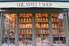 a store front with lots of glass windows and shelves filled with christmas items in the window