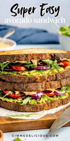 a sandwich with lettuce, tomato and cheese on it is cut in half