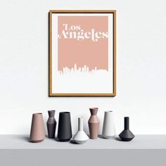 there are many vases on the shelf in front of the wall, and one is pink