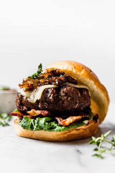 a close up of a hamburger on a bun with meat and cheese in the middle