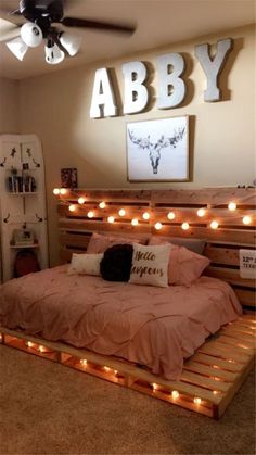 a bed made out of pallets with lights on the headboard