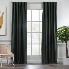 a living room with green curtains and a pink chair in front of a large window