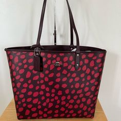 Printed Coated Canvas With Smooth Leather Details Reversible Double Flat Handles With 9” Drop Leather Hangtag Dustbag Open Closure Removable Large Wristlet-9 1/4"(L) X 5 3/4"(H) Comes With Care Card 13"(L) X 11 1/2"(H) X 6 1/4"(D) Red Coated Canvas Shoulder Bag For Everyday Use, Everyday Red Coated Canvas Shoulder Bag, Reversible Coated Canvas Bag For Everyday Use, Reversible Coated Canvas Everyday Bag, Everyday Reversible Coated Canvas Bag, Reversible Red Bag For Everyday Use, Red Reversible Shoulder Bag, Red Reversible Bag For Everyday Use, Red Reversible Bag For Shopping