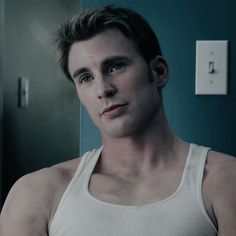 a man in a tank top looking at the camera