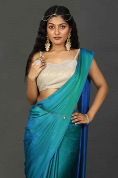 Engage your personality with the luxurious feel of this Satin One Minute Saree in Peacock Blue dual tone shades. It is paired with a stunningly shimmering beige blouse. Drape this specially for any festive, party, or wedding occasion.Product Features: Saree Color: Peacock Blue Blouse Color: Blue Saree Fabric: Satin Blouse Fabric: Blue Art Silk (Blouse Color: Blue Art Silk (For beige metallic blouse choose the fabric option at check out) Work: Ombre Shoulder Drape: Customer must select the should Peacock Blue Banarasi Saree, Traditional Blue Blouse Piece For Evening, Blue Traditional Drape Blouse For Evening, Traditional Drape Blue Blouse Piece For Evening, Blue Bollywood Style Formal Blouse Piece, Blue Bollywood Formal Blouse Piece, Blue Bollywood Blouse For Formal Occasions, Elegant Blue Choli With Traditional Drape, Elegant Turquoise Wedding Sets