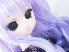 a doll with long purple hair and black eyeliners is posed in front of a white background