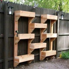 a wooden shelf sitting on the side of a fence