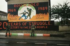 two soldiers are standing in front of a large sign