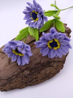 some purple flowers are sitting on a piece of wood