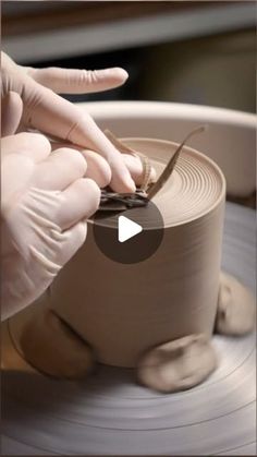 a person is making something out of clay on a potter's wheel with their hands