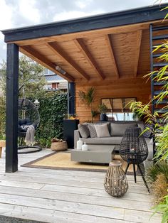 an outdoor living area with couches, tables and plants on the deck in front of it