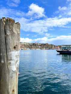 a boat is in the water next to a wooden post with a face painted on it