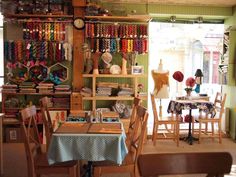 the inside of a craft shop with tables and chairs