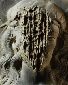 the head of a woman with long hair is shown in an intricately carved sculpture