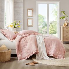 a bedroom with white walls and pink bedding