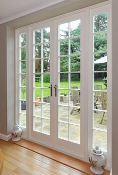 an empty room with french doors and chairs