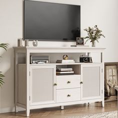 a flat screen tv mounted to the side of a white entertainment center in a living room