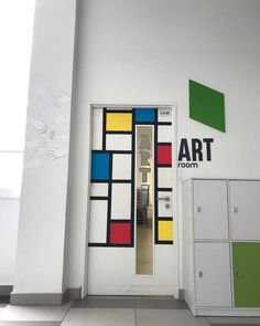 an art room with white cabinets and colorful doors