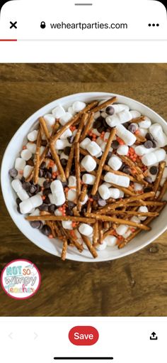 a bowl filled with marshmallows and pretzels on top of a wooden table