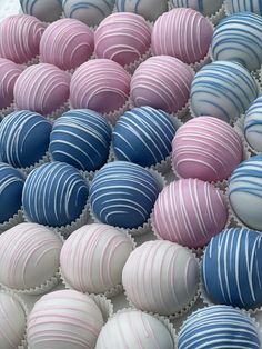 there are many pink and blue striped chocolates in the box on the table together