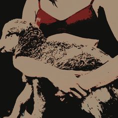 a woman is holding a sheep in her arms while wearing a red bra and black panties