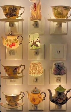 there are many cups and teapots on the wall in front of each other