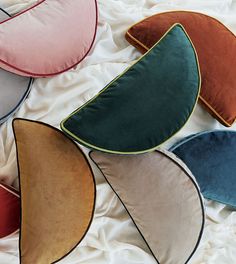 four different colored pillows laying on top of each other in the shape of curved shapes