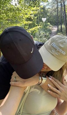 two people kissing each other in the woods