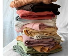 a stack of folded clothes sitting on top of a bed