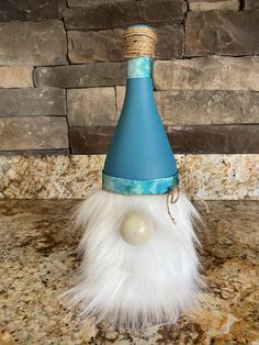 a blue cone with white feathers and a ball on it sitting on a counter top