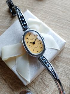 Retro Round Watch For Gift, Retro Round Watch As Gift, Classic Watches With Bracelet Strap As Gift, Elegant Automatic Watches For Gifts, Vintage Jewelry And Watches With Round Dial For Gift, Elegant Evening Analog Watch, Timeless Analog Jewelry And Watches As Gift, Elegant Adjustable Watch With Round Dial, Handmade Elegant Formal Watches