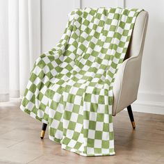 a green and white checkered blanket sitting on top of a chair