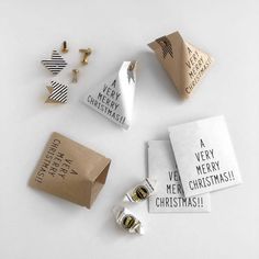 several different types of christmas decorations on a white surface with some wrapping paper around them