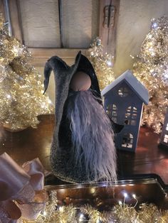 a black bag sitting on top of a wooden table next to christmas trees and lights