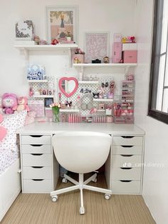 a white desk topped with lots of drawers next to a wall filled with pictures and toys