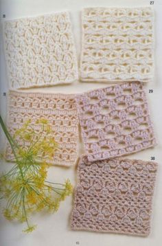 four crocheted squares sitting on top of a table next to a vase with flowers