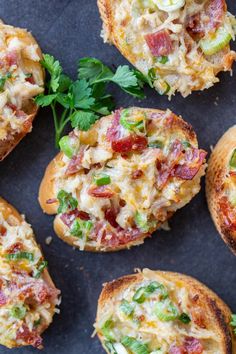 several mini pizzas with different toppings on top of each one and garnished with parsley