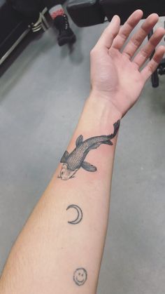 a person's arm with a tattoo on it and a fish in the water