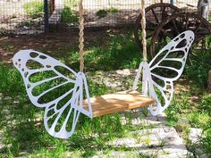 a white butterfly shaped swing hanging from a rope