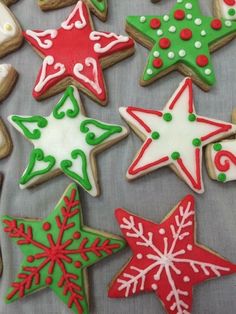 christmas cookies decorated with icing and decorations on a sheet of baking paper in the shape of stars