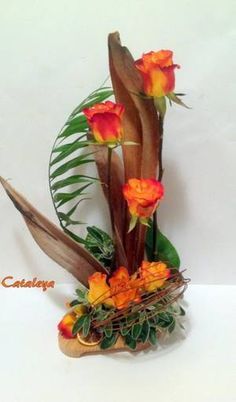 an arrangement of flowers in a vase on a white surface with the words caulda written below it