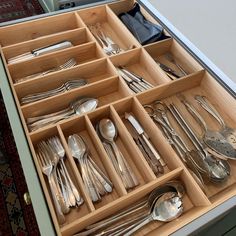 an open drawer with silverware in it