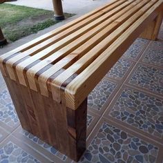 a wooden bench sitting on top of a tiled floor