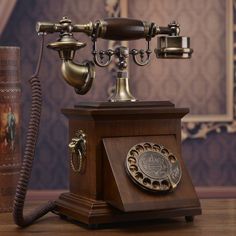 an old fashioned phone sitting on top of a wooden table