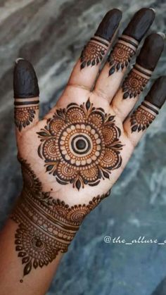 a woman's hand with hennap on it and an intricate flower design