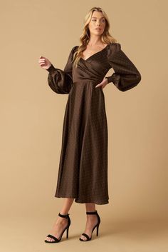 An embellished woven midi dress featuring a surplice neckline, long sleeve with smocked cuff, A-line skirt, and back zipper closure Details: Self: 100% Polyester Lining: 100% Polyester Size & Fit - Model is 5`8" And Wearing Size Small- Measurements Taken From Size Small- Approx. Length: 49" Brown Puff Sleeve Dress With Smocked Bodice, Brown A-line Midi Dress For Evening, Flowy Long Sleeve Brown Midi Dress, Brown Long Sleeve Midi Dress With Buttons, December Wedding Guest Dress, Luxury Brown A-line Midi Dress, Winter Wedding Guest Dress, Winter Wedding Guests, What To Wear Fall